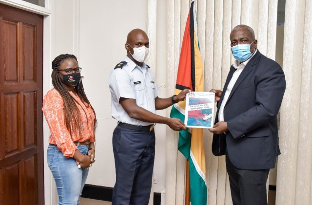 Draft Oil Sprill plan being presented to the Prime Minster (right) by Director General of the Civil Defence Commission